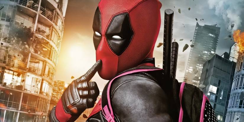 Deadpool touching his finger to his mouth with explosions going off in the city behind him.