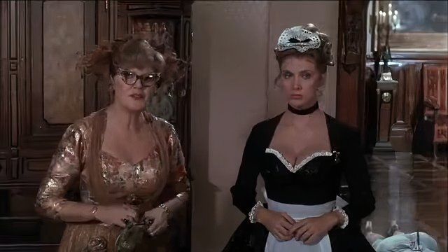 Eileen Brennan as Mrs. Peacock standing next to Colleen Camp as Yvette in Clue