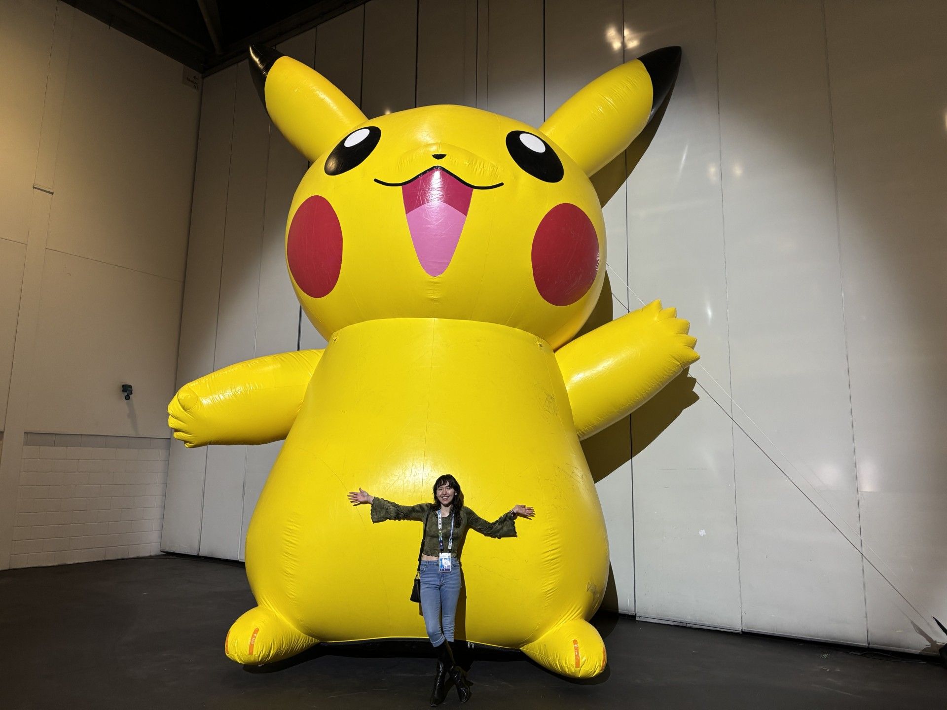 A woman standing in front of an inflatable giant Pikachu.