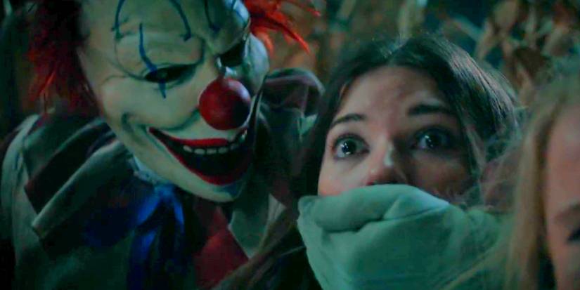 Frendo holding his hand over a teenager's mouth in Clown in a Cornfield