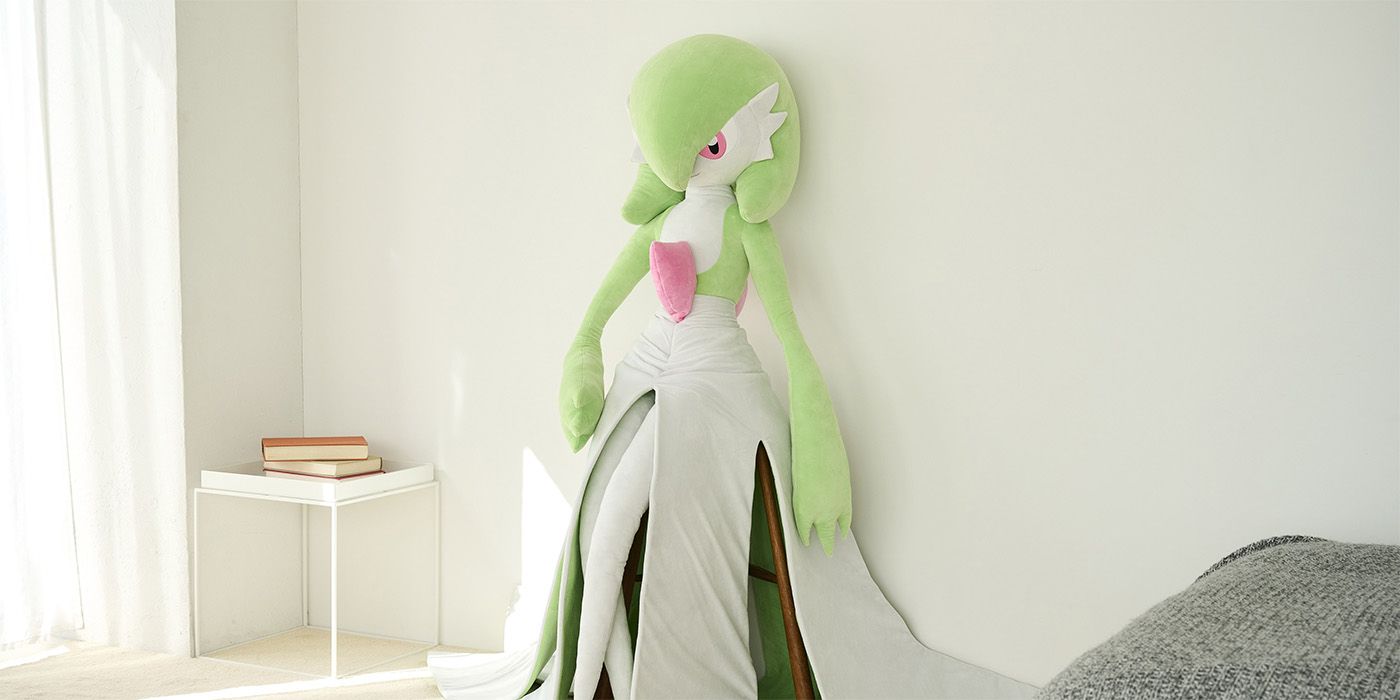 life-sized gardevoir pokemon plush leaning against a wall in a bedroom