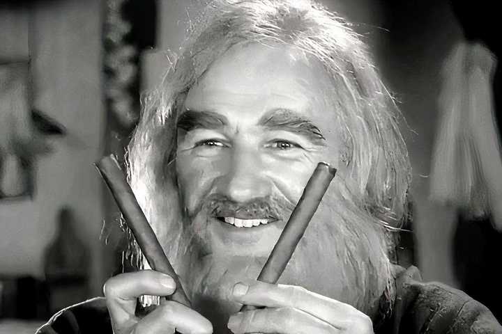 Gene Hackman holding two sticks and smiling in Young Frankenstein