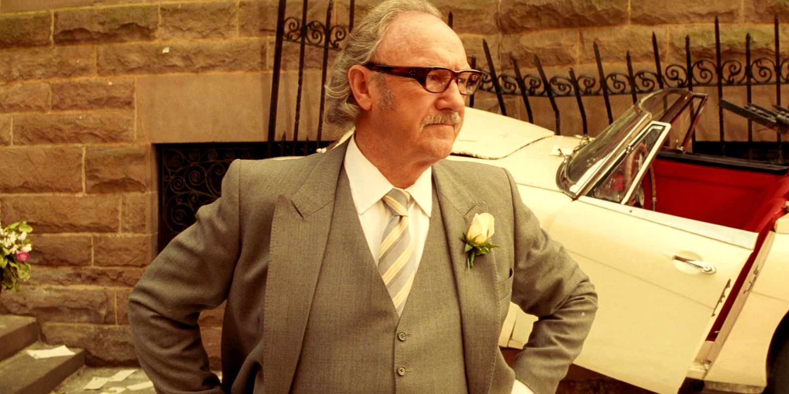 Gene Hackman with his hands on his hips in a suit in The Royal Tenenbaums