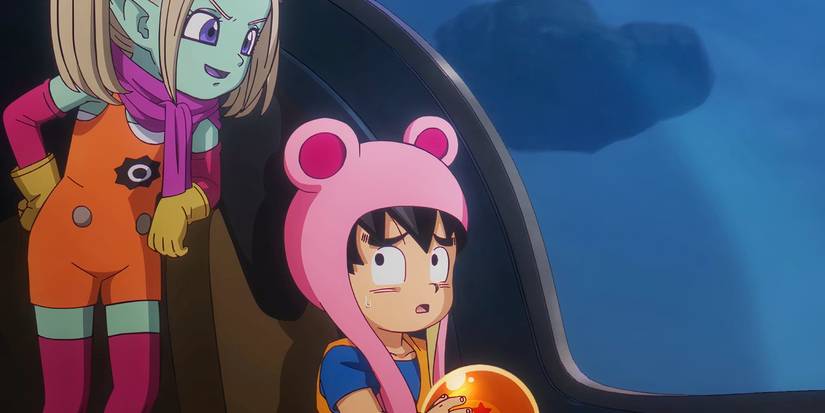 Goku wearing a hat looking at Panzy sadly while holding a Dragon Ball in Dragon Ball Daima.