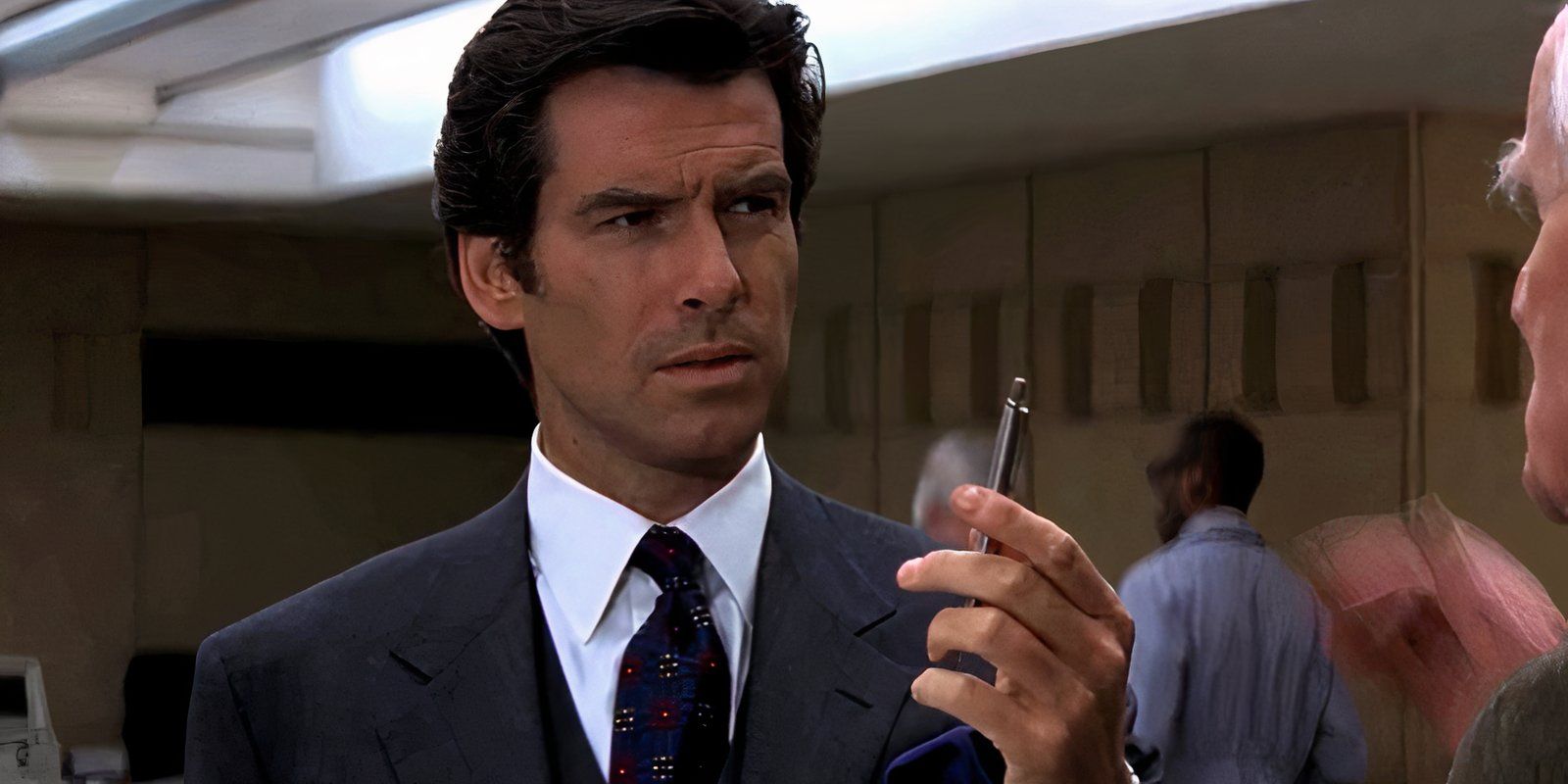 Pierce Brosnan holds up a pen as James Bond in GoldenEye