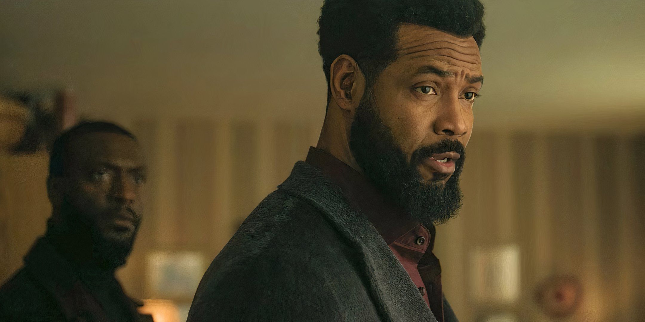 Isaiah Mustafa as John Sampson talking to someone with Alex behind him in Cross