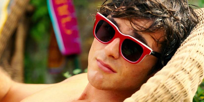 Jacob Elordi lounging while wearing sunglasses in Saltburn