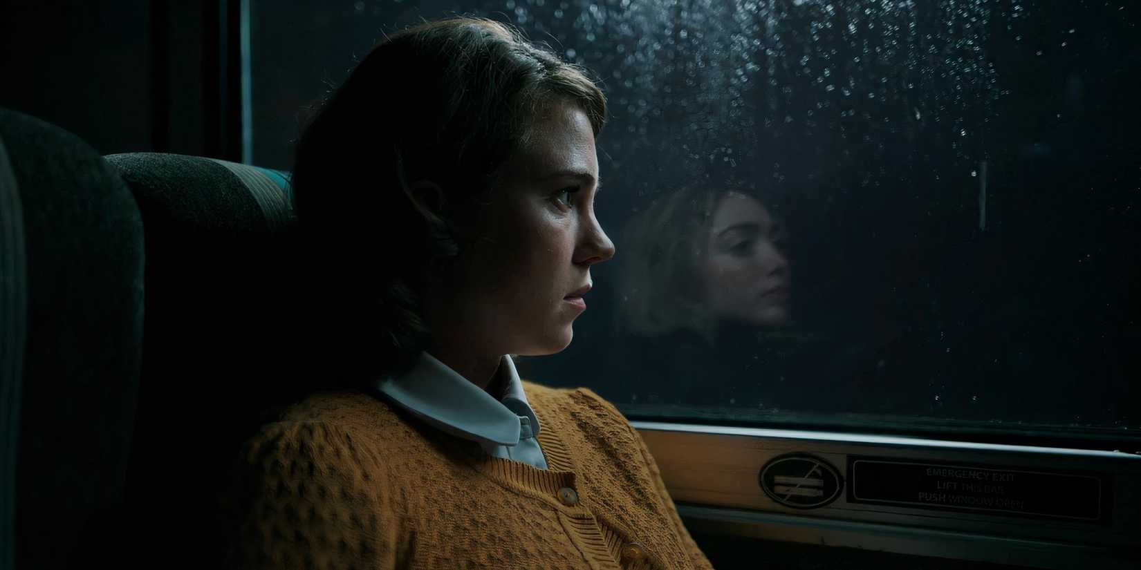 Actress Jess Gabor as Janet looking out the window, with Maddie's reflection in the glass beside her, in School Spirits season 2. 