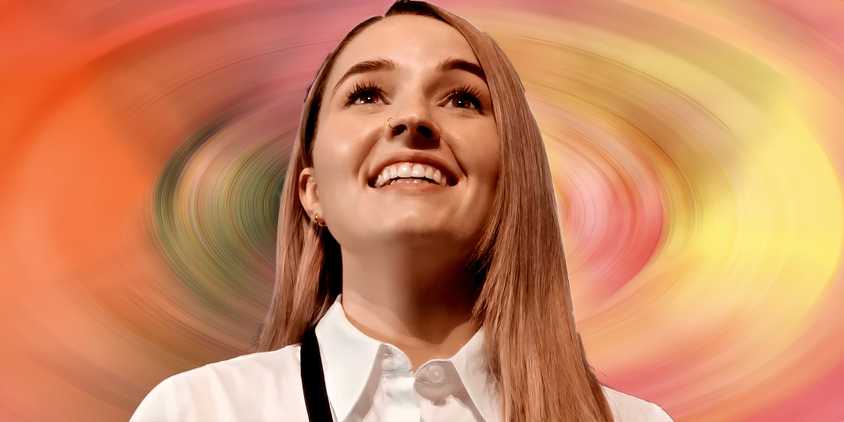 Kaitlyn Dever as Belle smiling against blurred Apple Cider Vinegar Poster backdrop
