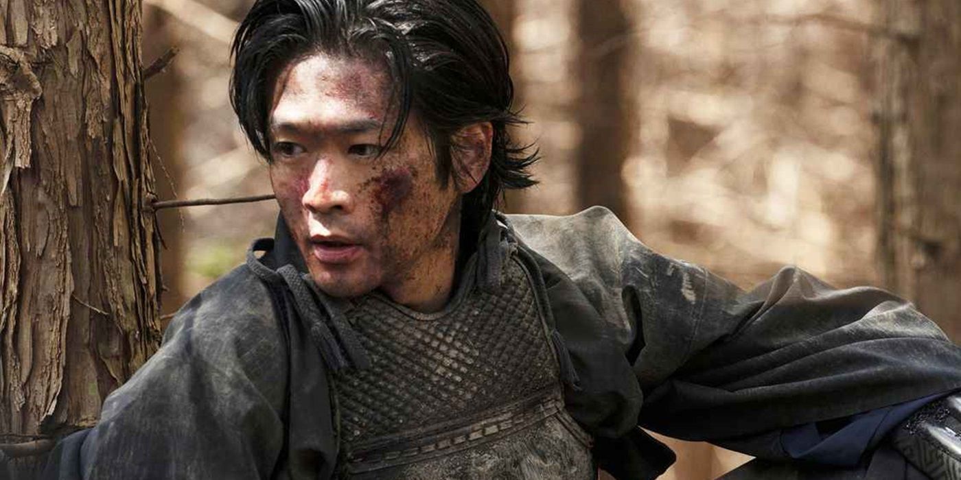 Man with a bruised face leaning against a tree in Last Samurai Standing