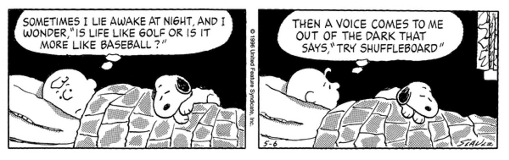 Charlie Brown wide awake with Snoopy at the foot of his bed.