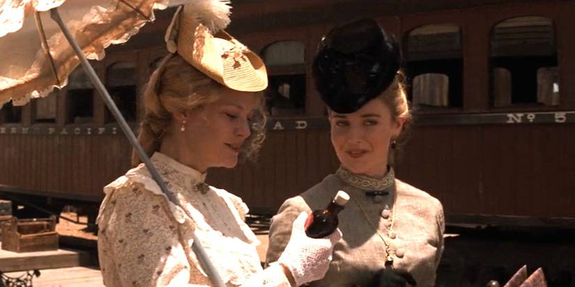 Mattie Earp (Dana Wheeler-Nicholson) takes a bottle of laudanum from Allie Earp (Paula Malcomson) in Tombstone