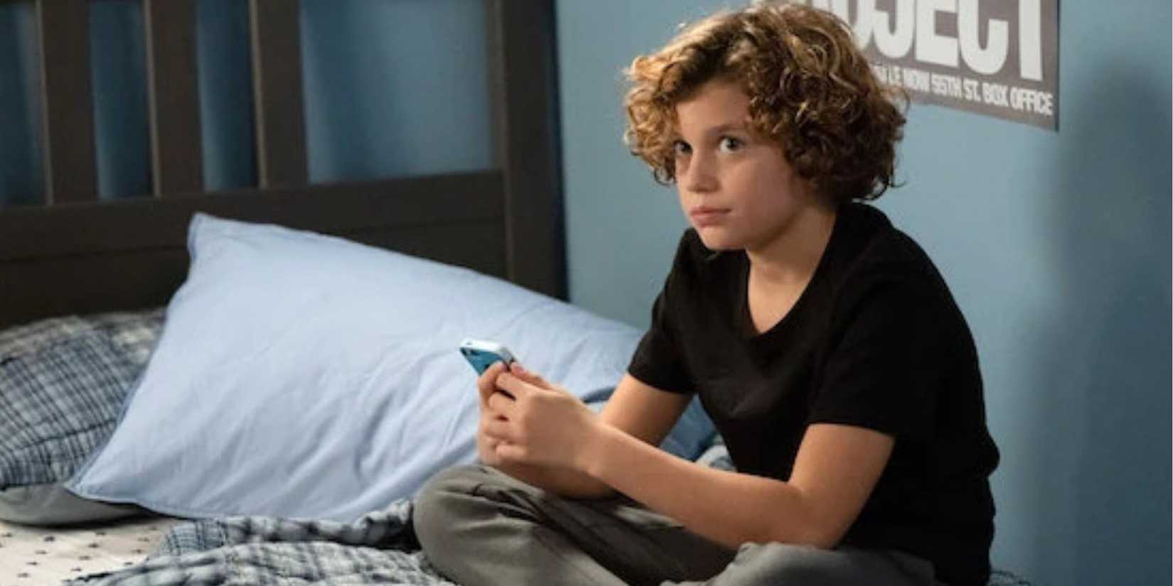 Law & Order SVU Ryan Buggle as Noah sitting on his bed with his phone