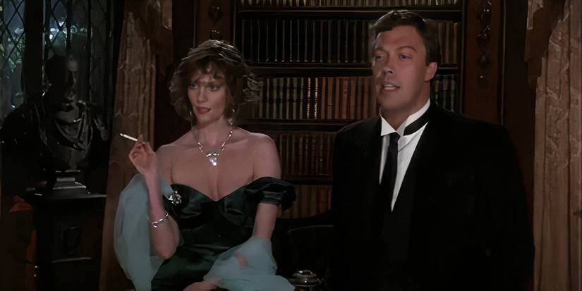 Lesley Ann Warren as Miss Scarlet sitting by Tim Curry as Wadsworth in Clue