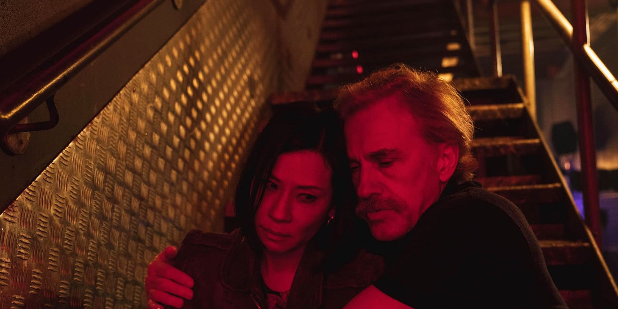 Lucy Liu ir Christoph Waltz sename vaikinyje, kai sėdi ant laiptų 