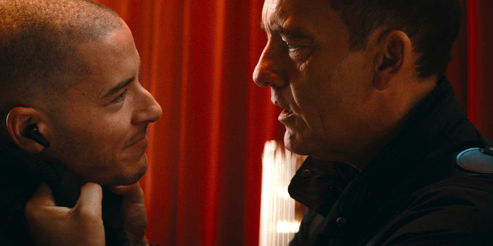Marcus grabs a smiling Noah by the front of his clothes in Cleaner