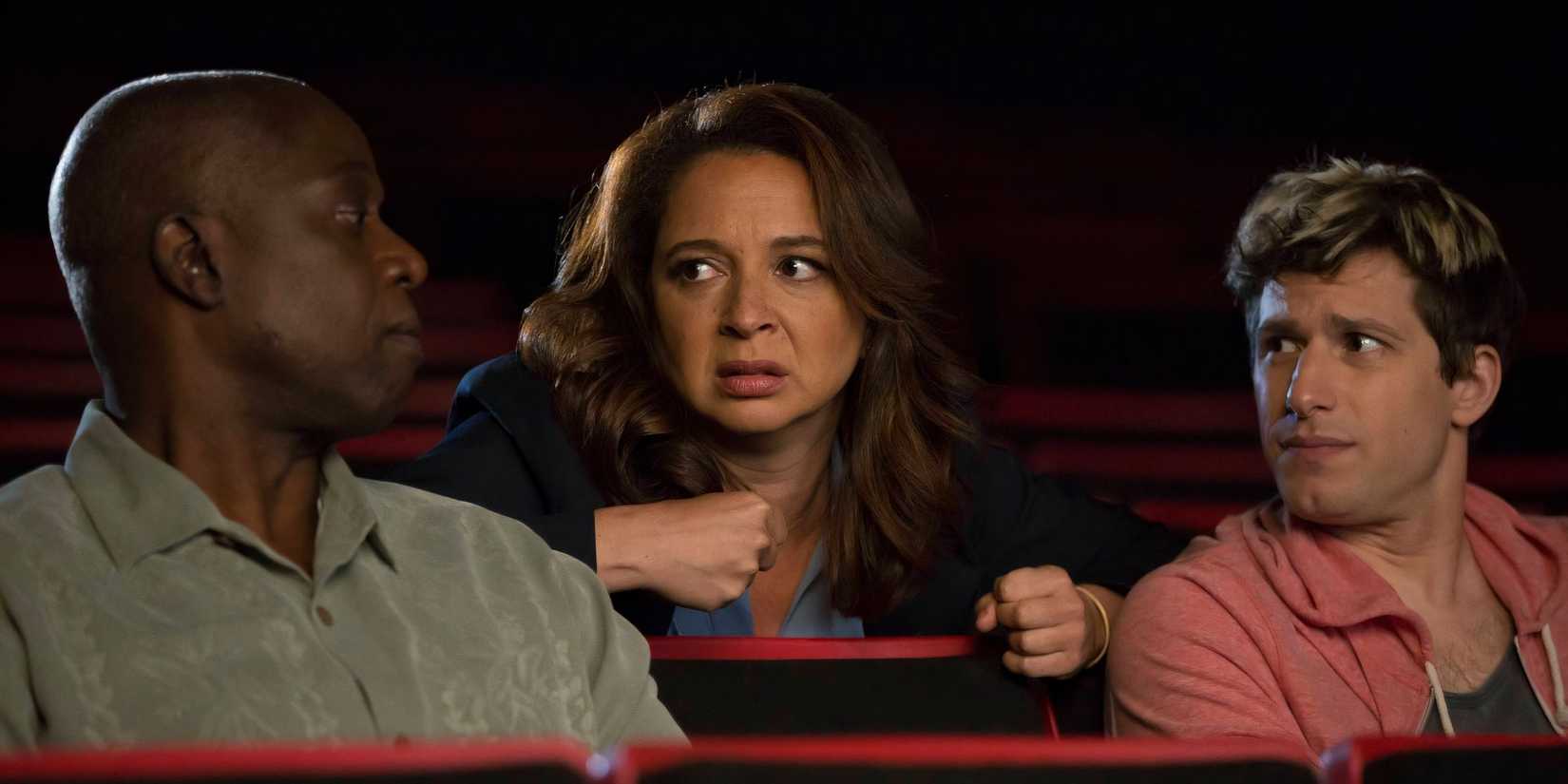 Maya Rudolph behind Andre Braugher and Andy Samberg in a theater in Brooklyn Nine Nine
