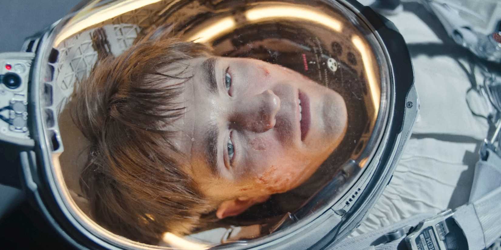 Mickey (Robert Pattinson) wearing an astronaut suit, agonizing in Mickey 17