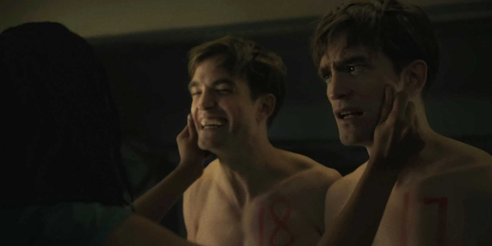 Nasha pinching the cheeks of Mickey 17 and Mickey 18 (Robert Pattinson) in Mickey 17