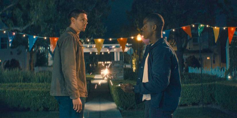 Billy Pace (Jon Beavers) and Xavier Collins (Sterling K. Brown) talking at night and in front of carnival flags in Paradise season 1, episode 4