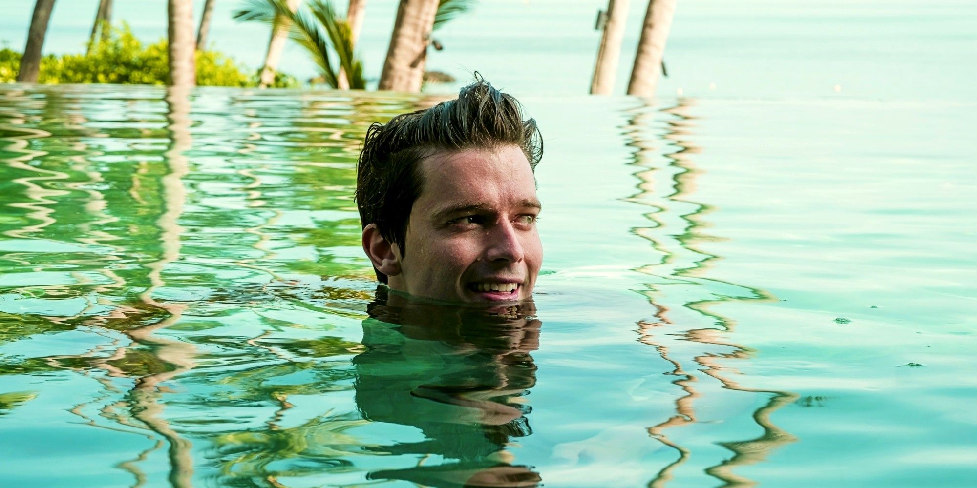 Patrick Schwarzenegger chills in a pool with only his head above the water in The White Lotus season 3