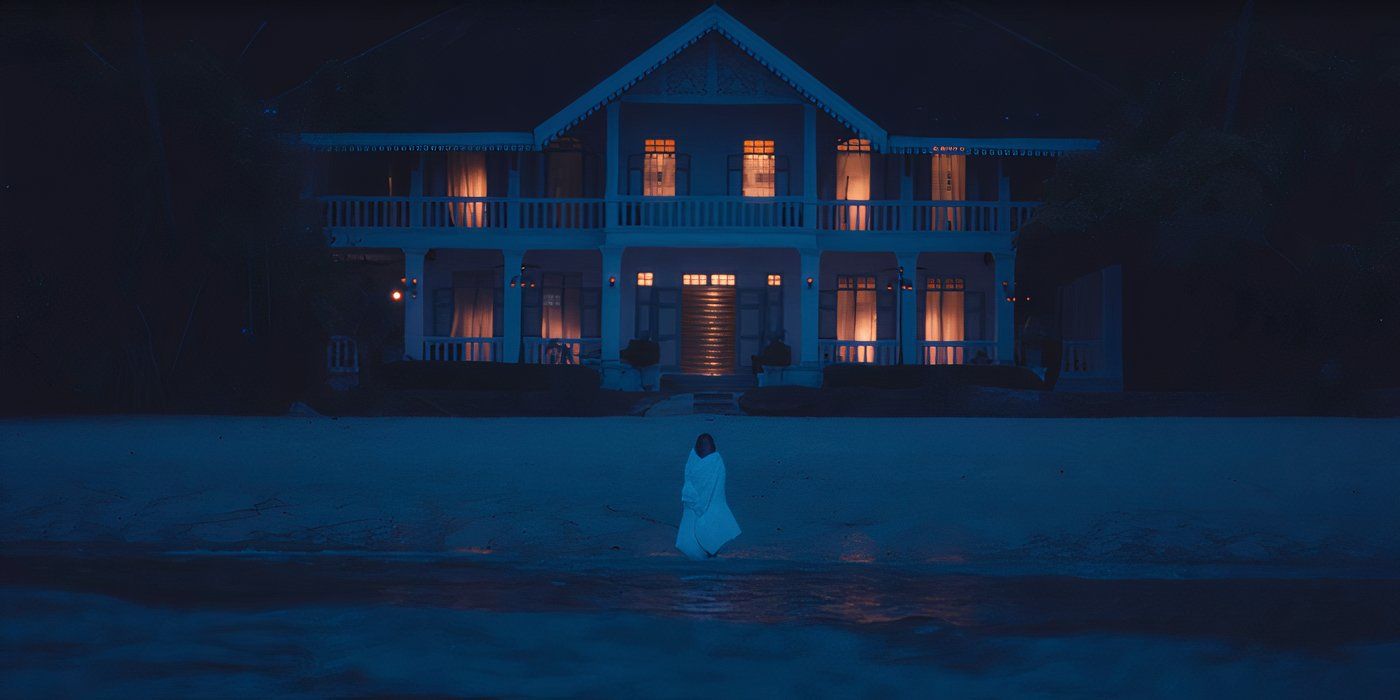 Victoria wrapped in a white comforter on a beach, standing in front of Ratliff's house in season 3 of Lotus White, sequence of the dreams of episode 3