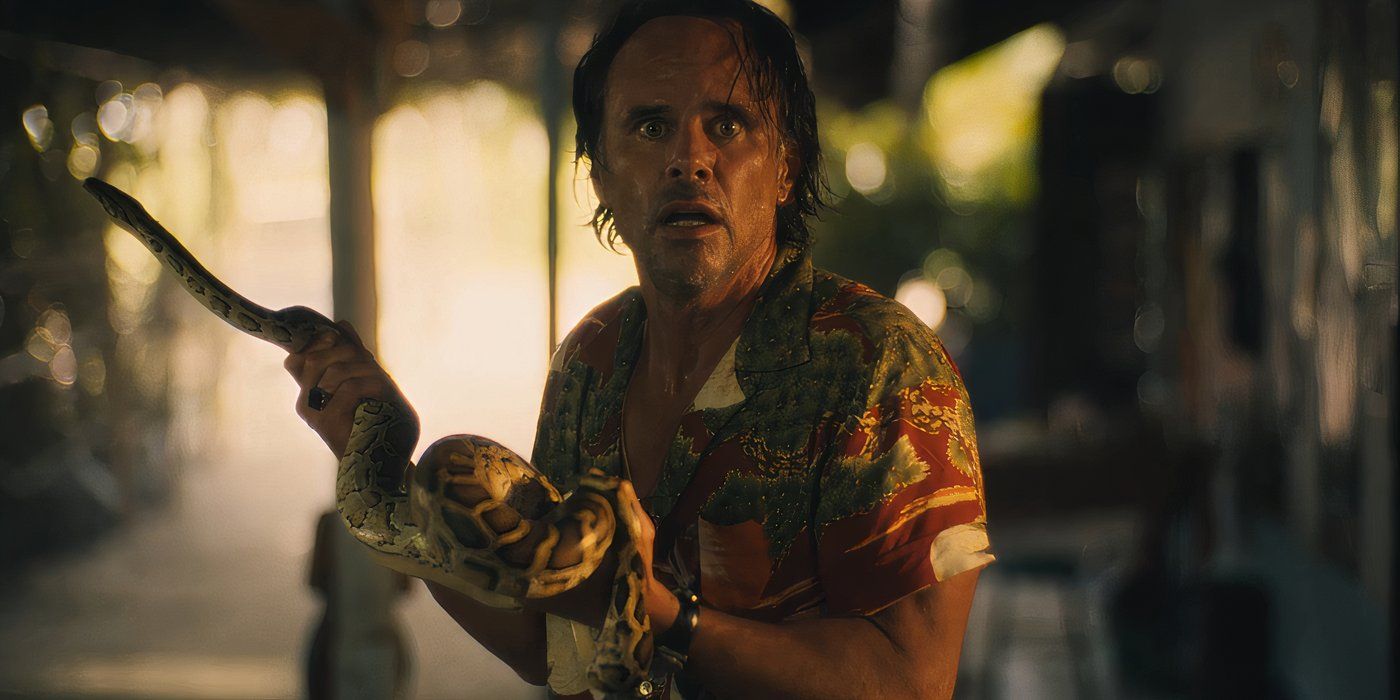 Walton Goggins as Rick looking shocked by holding a snake in Season 3 of Lotus White (2025)