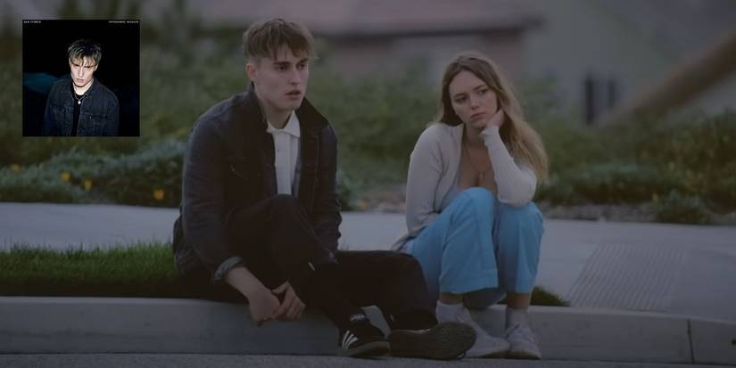 Sam Fender sitting on the curb next to a girl in the Hypersonic Missiles Music Video with the album art in the top left corner