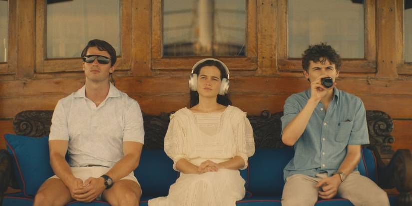 Saxon (Patrick Schwarzenegger), Piper (Sarah Catherine Hook), and Lochlan (Sam Nivola) all sitting on a boat in White Lotus season 3, episode 1.