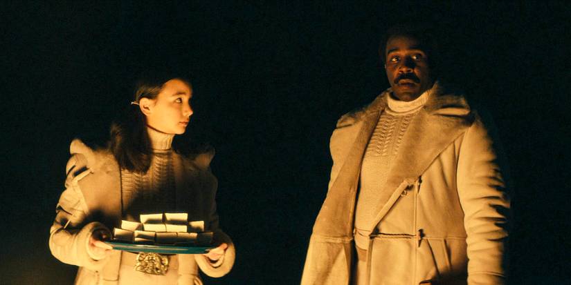 Miss Huang (Sarah Bock) and Milchick (Tramell Tillman) preparing everything for the campfire in Severance Season 2 Ep 4