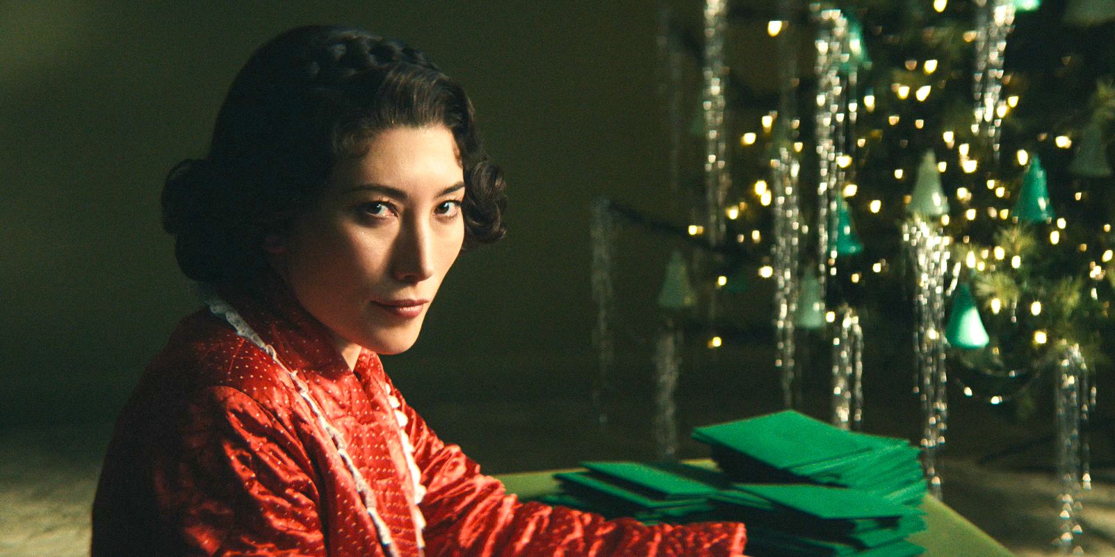 At Lumon, Gemma (Dichen Lachman) wearing a red robe in front of the Christmas tree in Severance Season 2 Ep 7