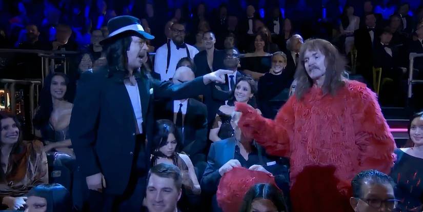 Jason Sudeikis and Will Forte point at each other while wearing costumes with Jenna Ortega and Kevin Costner between them on SNL 50
