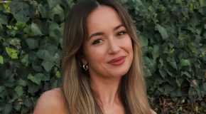 The Bachelor Carolina Sofia posing outside in front of leafy hedge and smiling