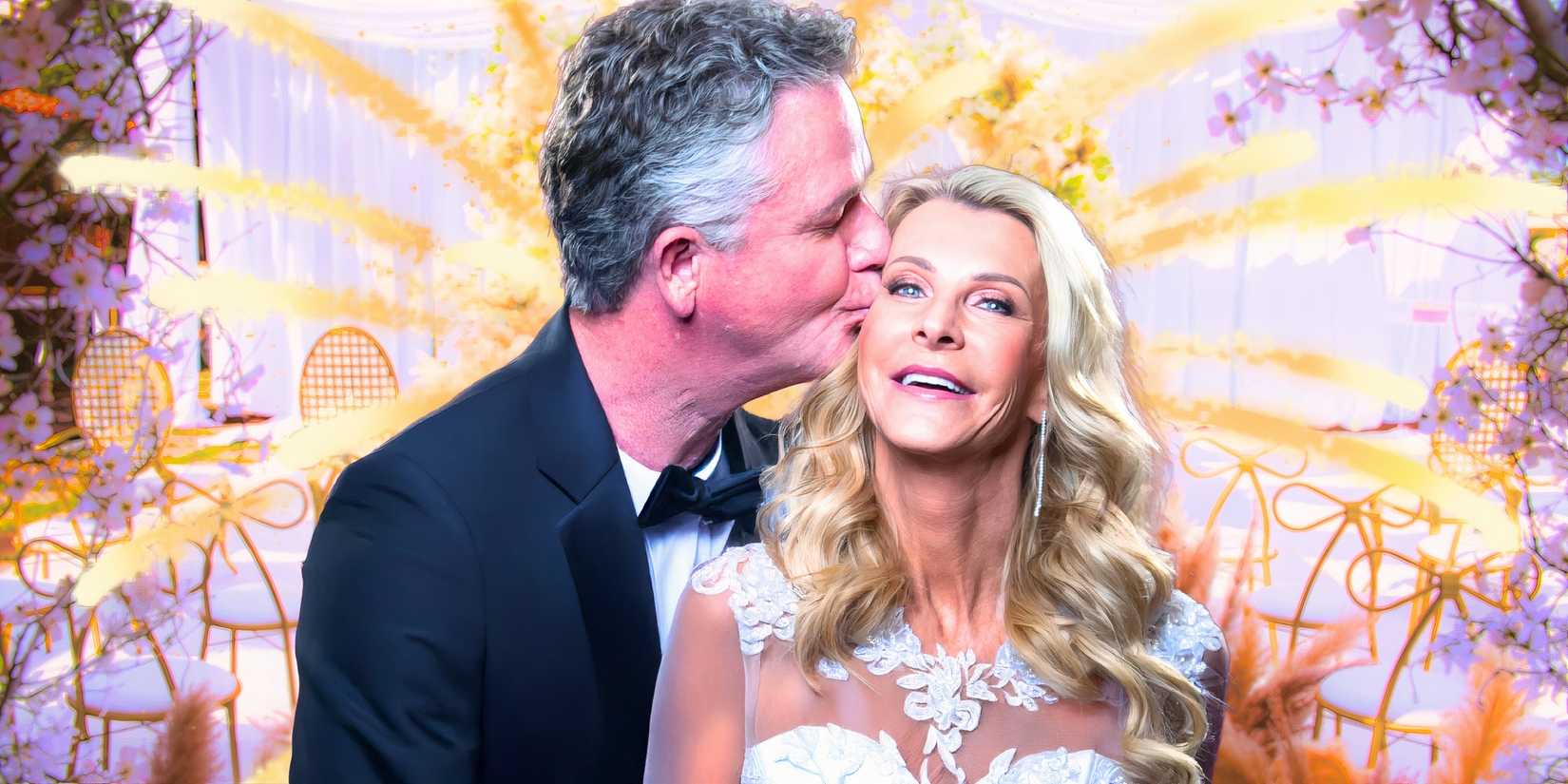 Image of Joan Vassos & Chock Chapple from the golden bachelorette in wedding attire with pastel background