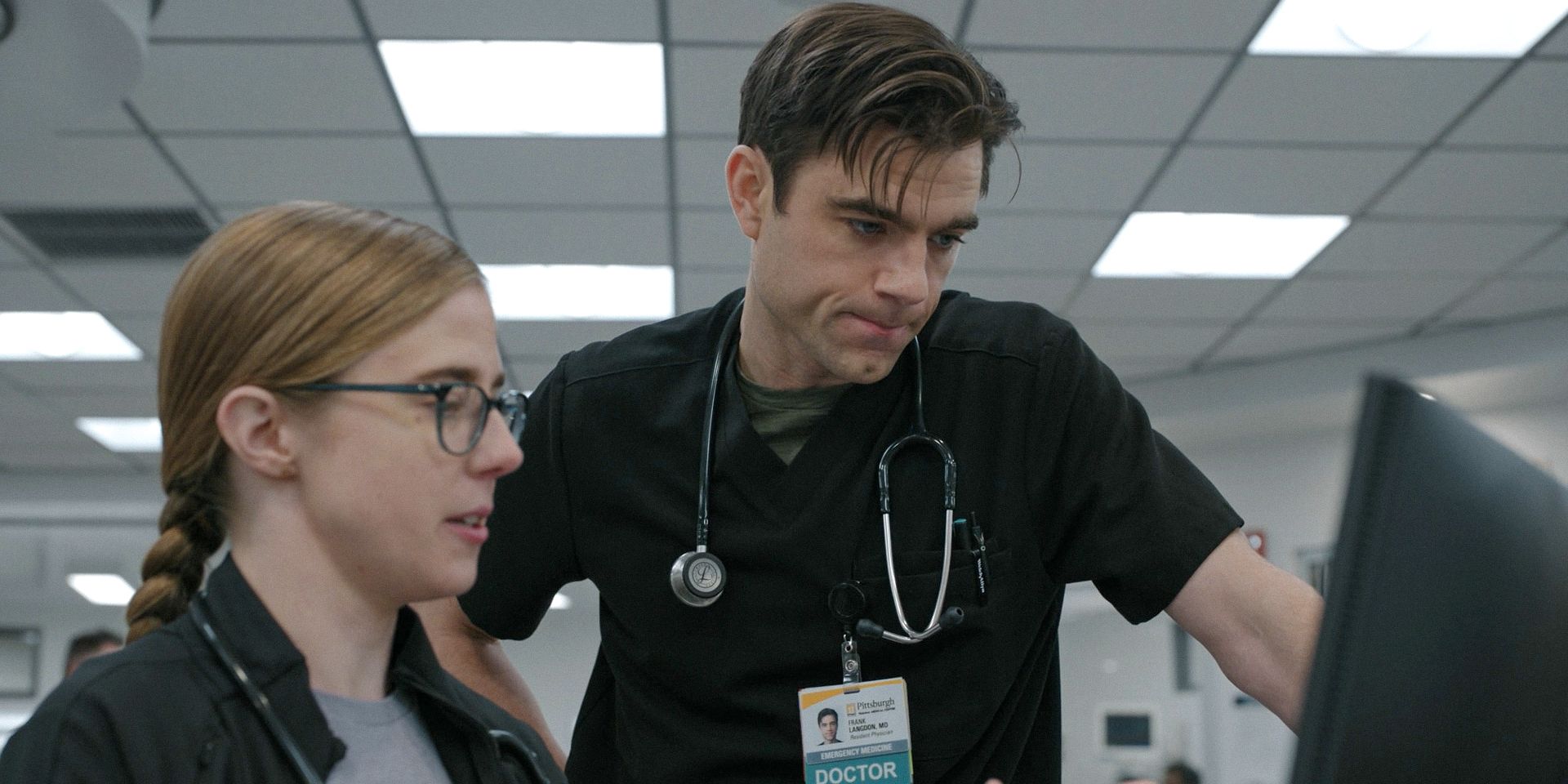 Dr. Melissa King (Taylor Dearden) helps Dr. Frank Langdon (Patrick Ball) with a patient's file in The Pitt Season 1 Ep 7