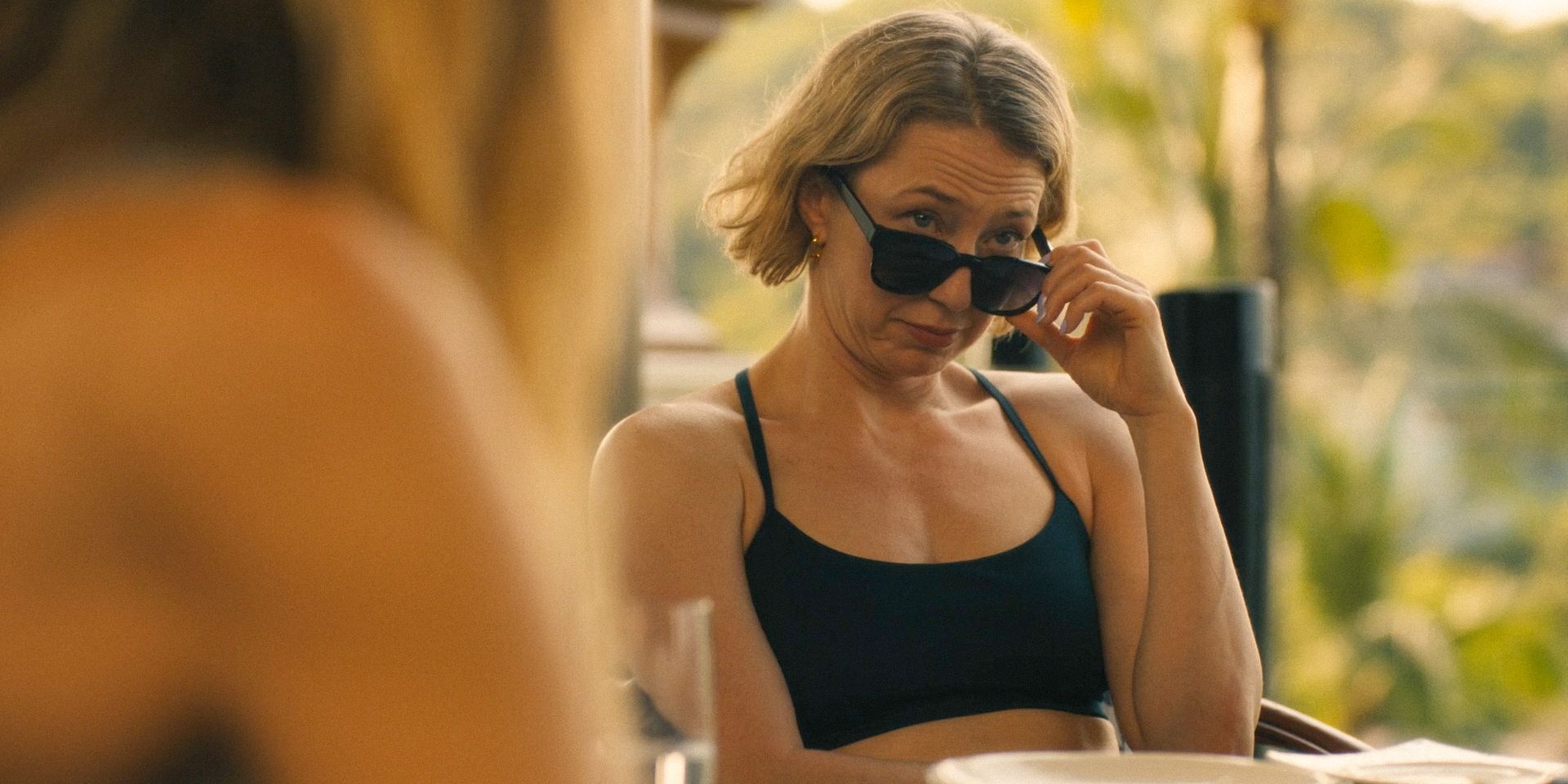 Laurie (Carrie Coon) lowers her sunglasses to take a look at Valentin in The White Lotus Season 3 Ep 2