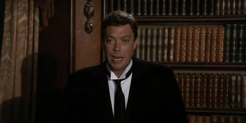 Tim Curry as Wadsworth talking to the guests in Clue.