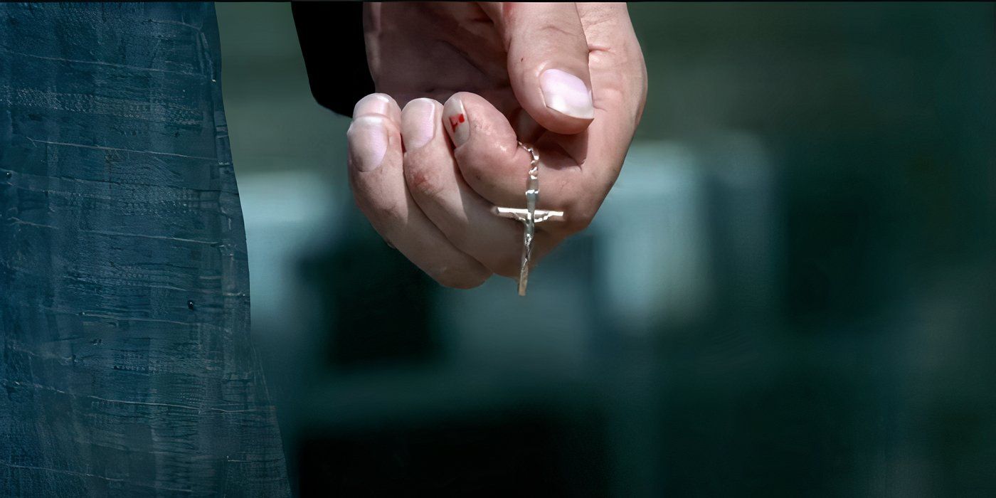 Abruzzi's hand holding a crucifix in Prison Break