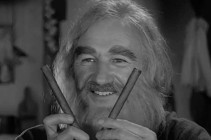 Gene Hackman holding two sticks and smiling in Young Frankenstein