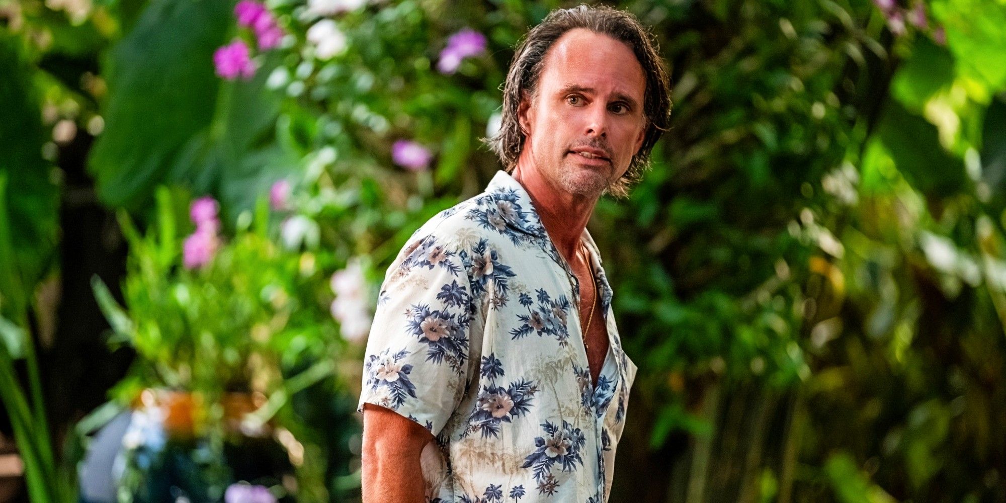 Walton Goggins stands near some tropical foliage in The White Lotus season 3