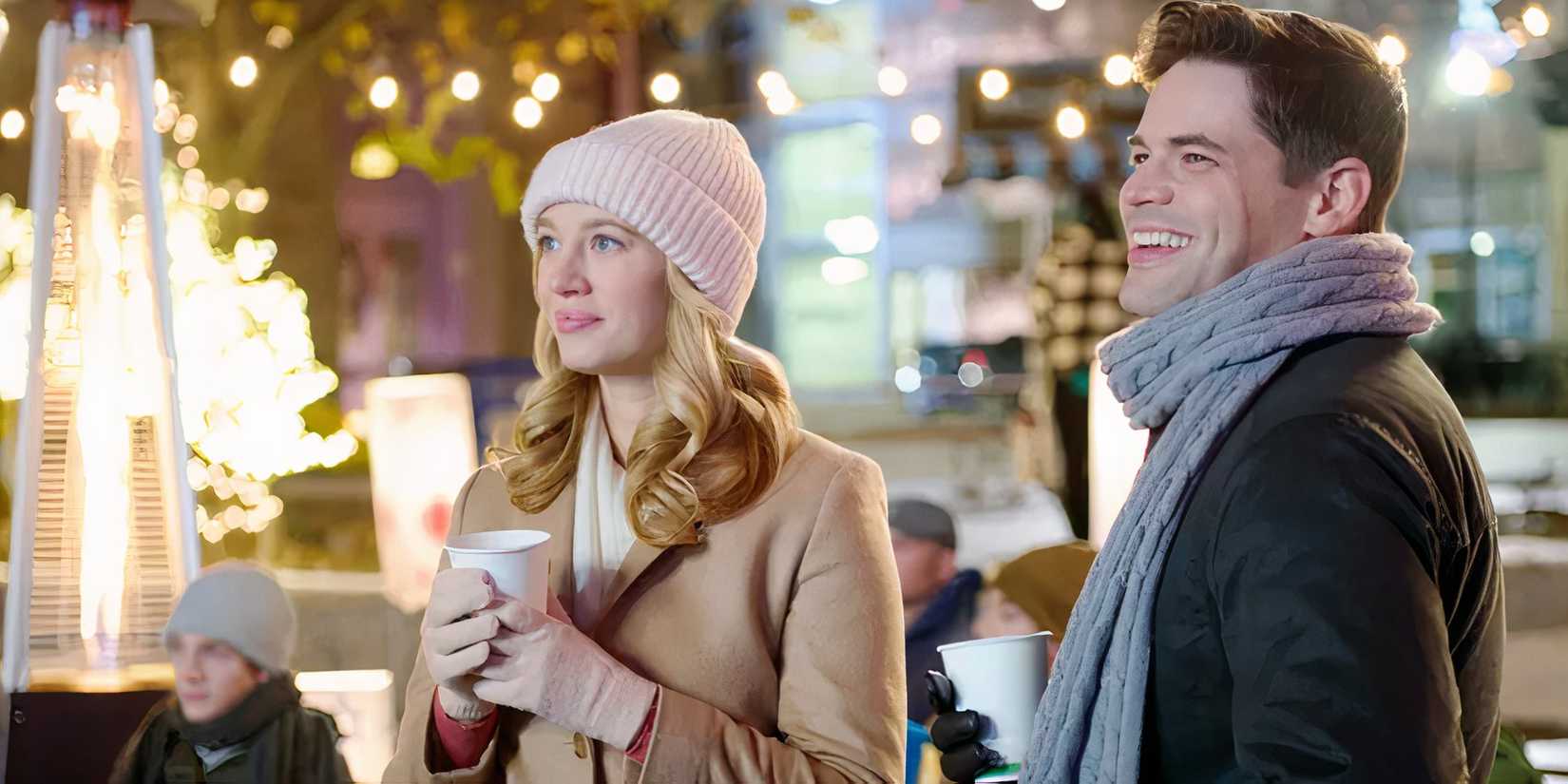 Yael Groblas and Jeremy Jordan standing next to one another smiling in winter wear in Hanukkah on Rye