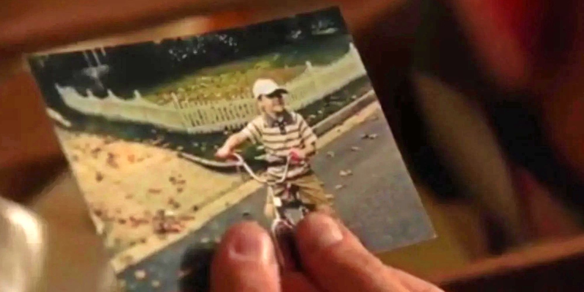 Buck holding a picture of a young boy on a bike in 9-1-1 season 4.