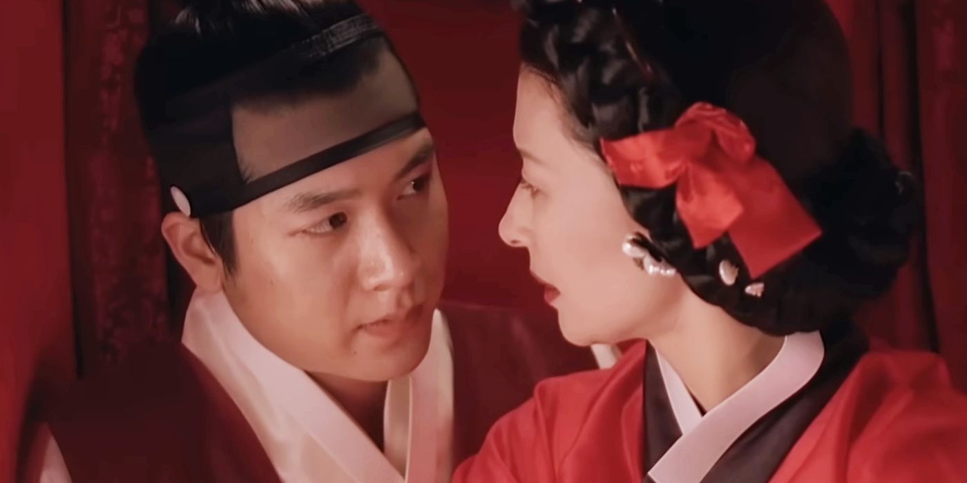 A couple looking at one another in a carriage in Untold Scandal 2003