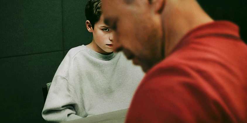 Jamie Miller peeking out from behind the profile of an adult man on the Adolescence Poster