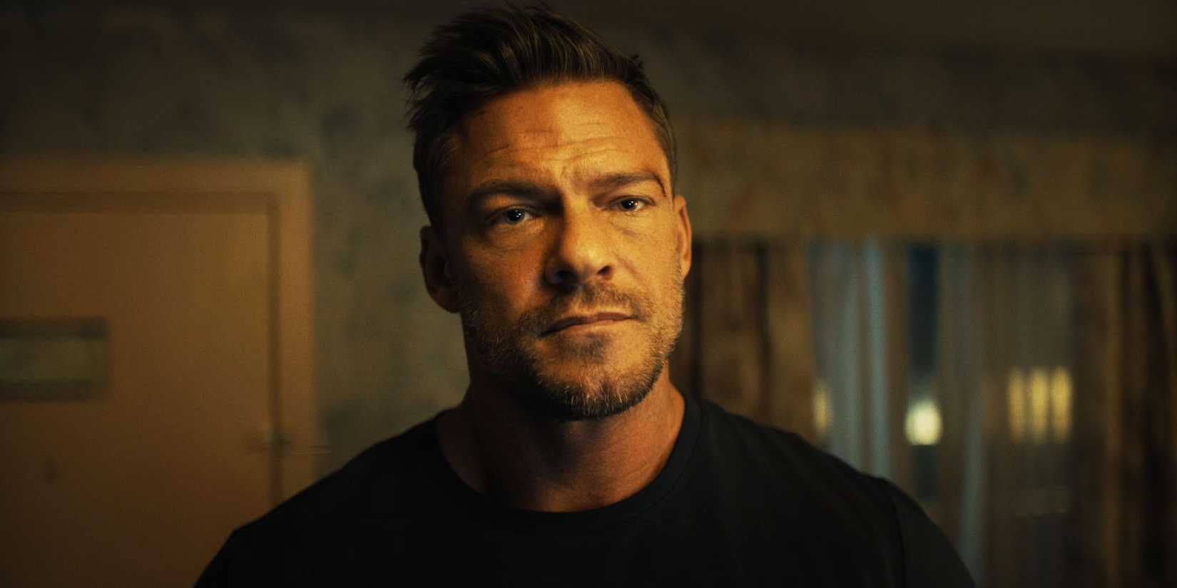 Alan Ritchson as Jack Reacher looking at someone in season 3.