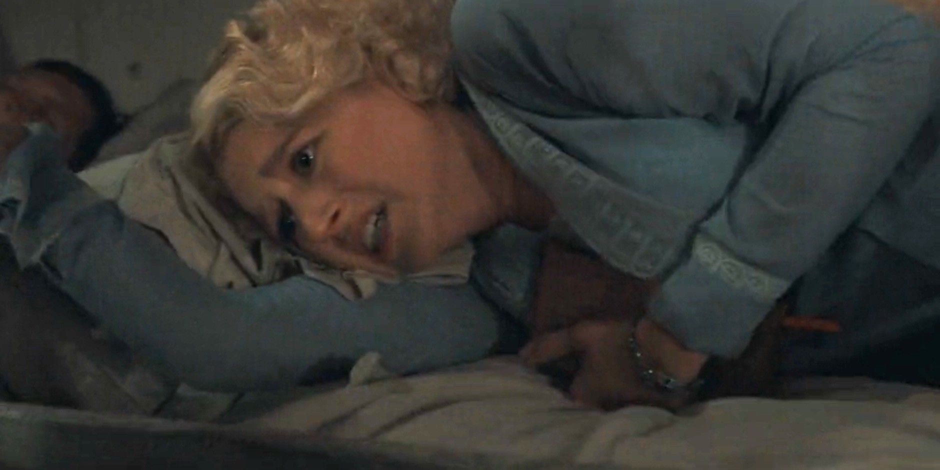 Alexandra Dutton (Julia Schlaepfer) looking terrified as she clings to a pillow in 1923 season 2, episode 2