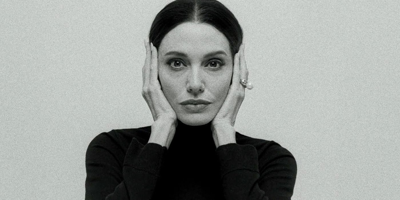 Angelina Jolie as Maria Callas holding her face in black and white in Maria