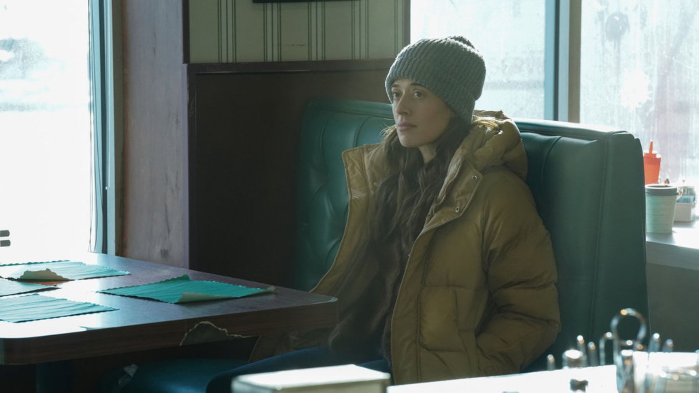 Burgess sitting at a table in a diner with a lot of file folders in Chicago PD
