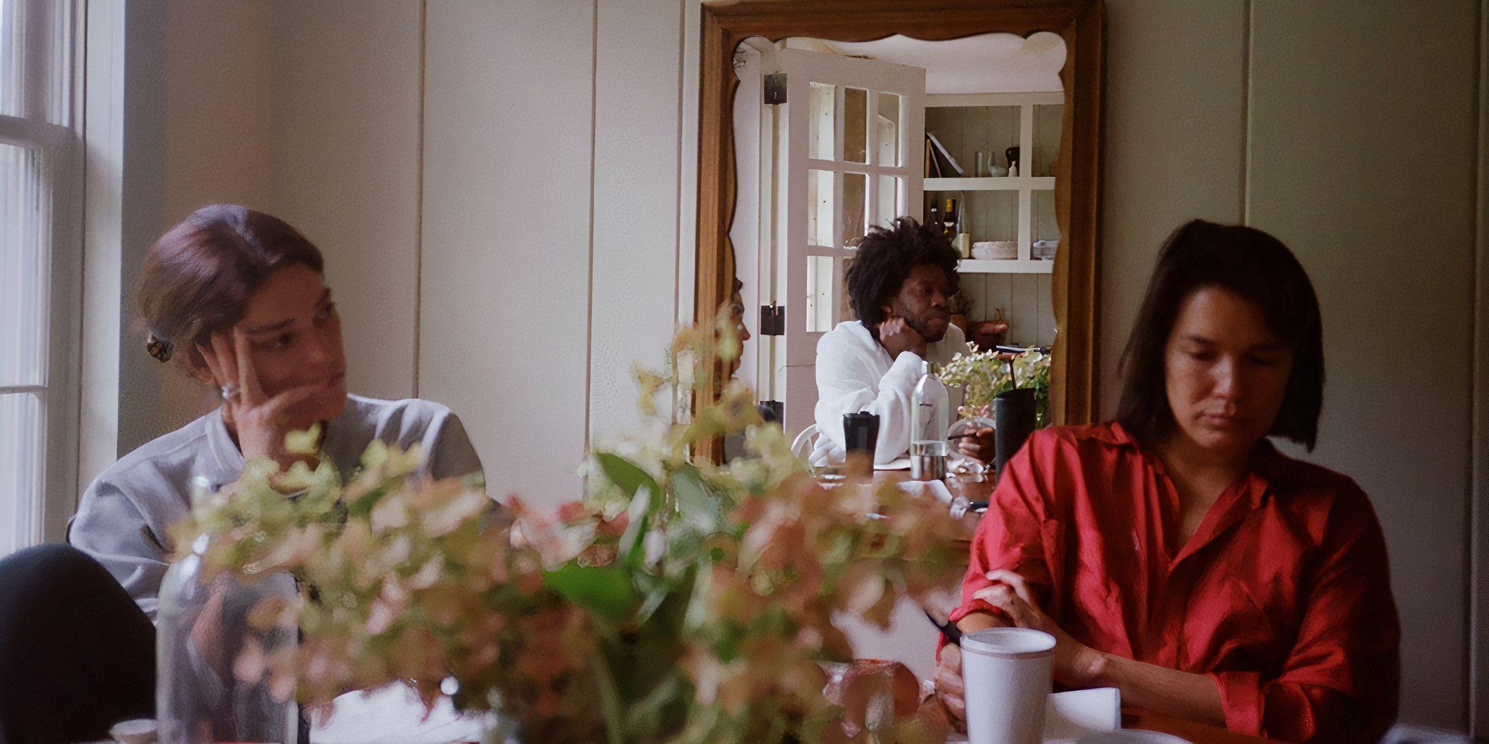 Callie Fernandez's Camille, Jeremy O. Harris' Isaac and Zoë Chao's Yvonne sitting at the dining table in The True Beauty of Being Bitten by a Tick