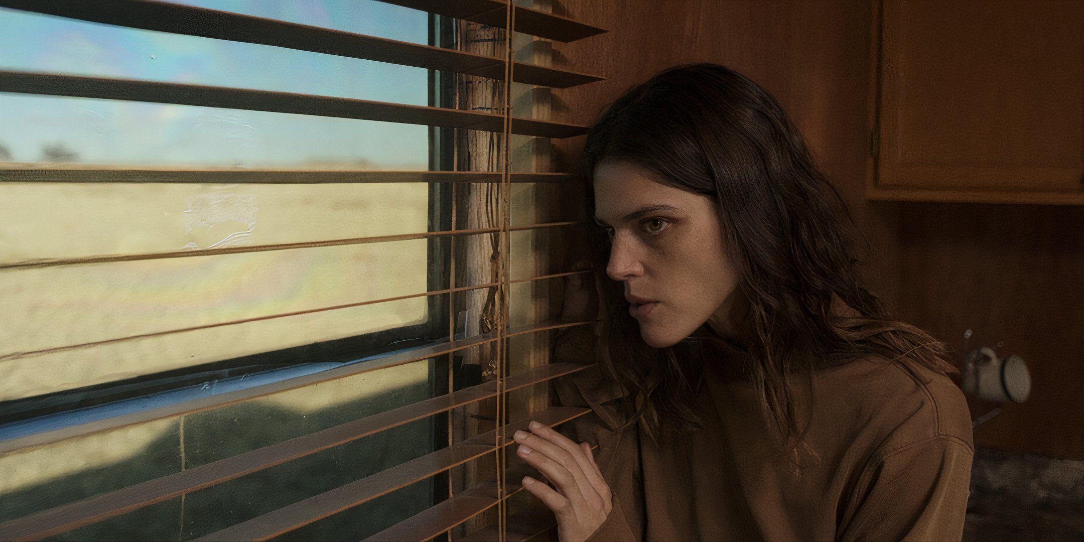 Callie Hernandez looking worried out of a window in Jethica
